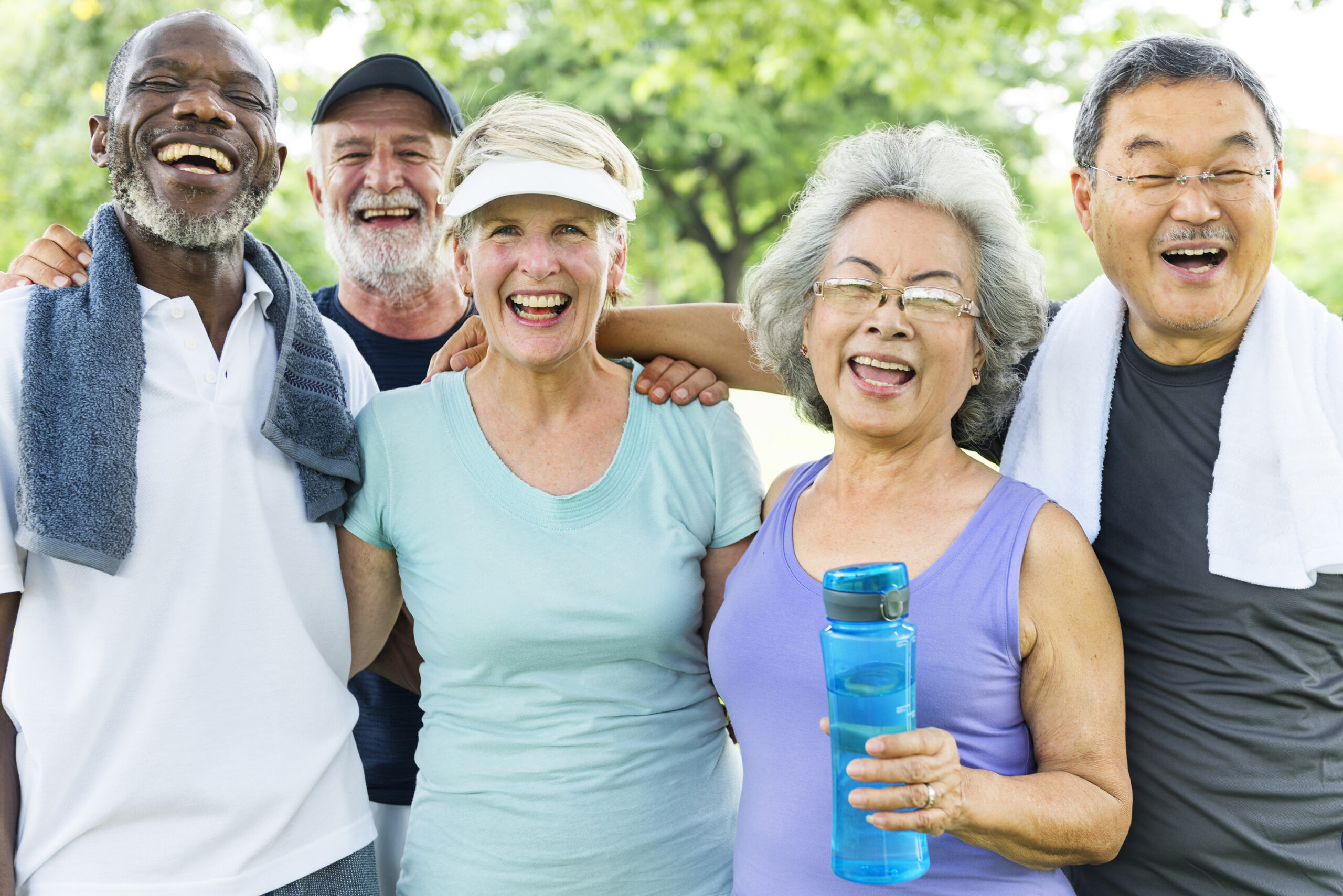 Elderly men and women smiling outside in athletic attire