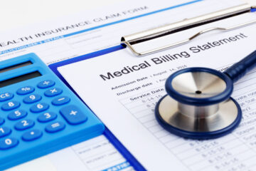 Image of medical billing statement with calculator and stethoscope on top